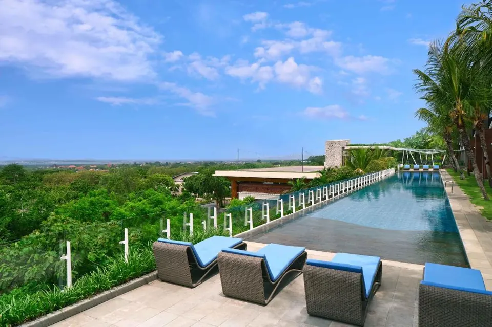 Infinity pool and sun loungers at Four Points by Sheraton Bali Ungasan