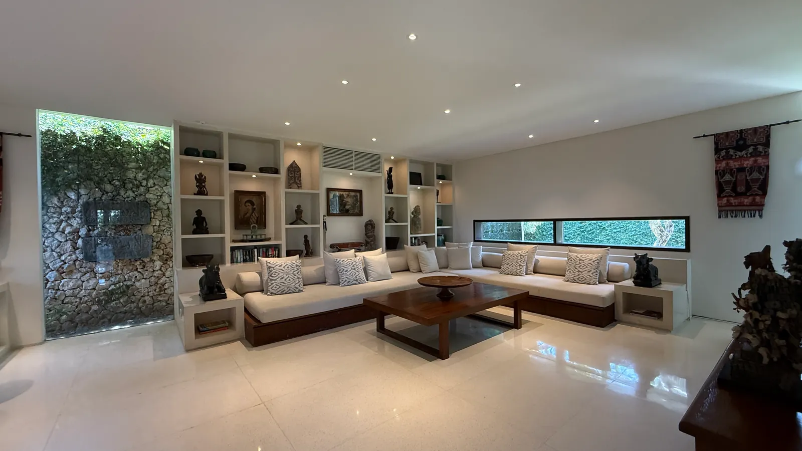 Villa lounge with built-in sofas and Balinese art at The Ungasan